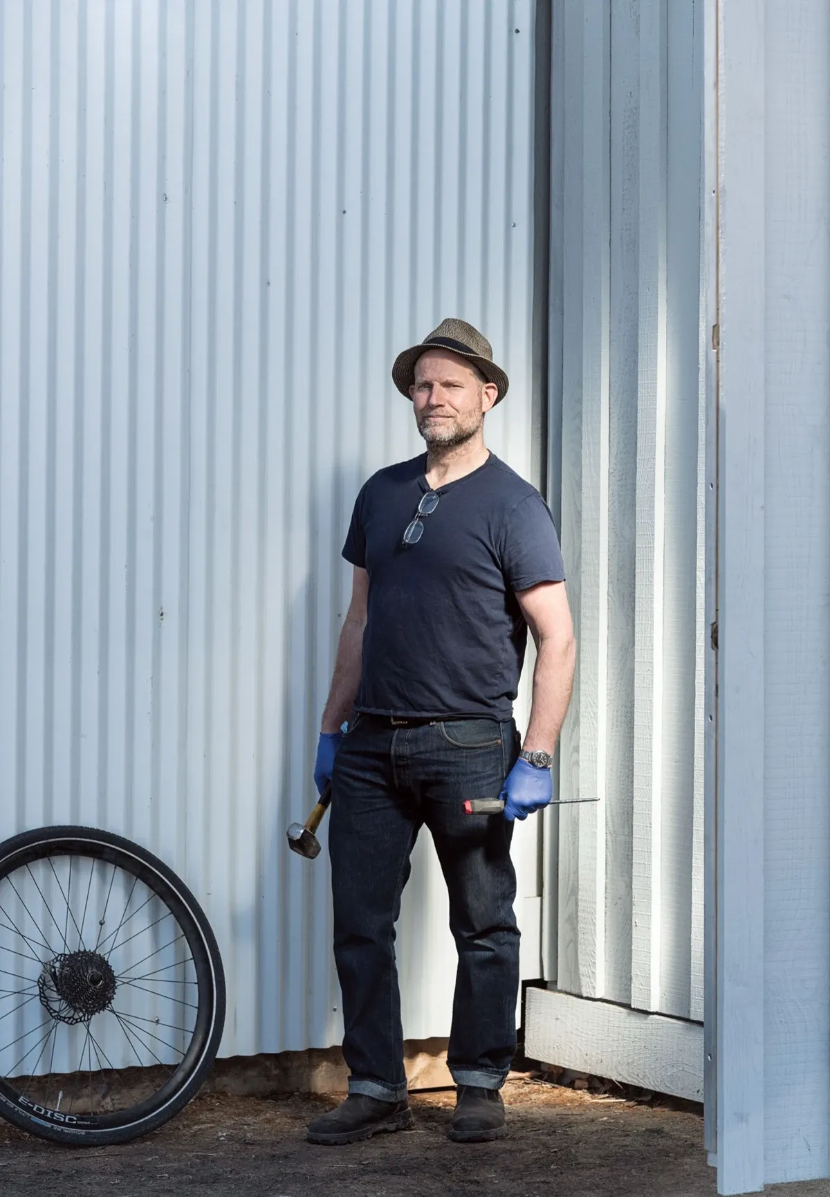 Joe Nunn, portrait by Jared Sych, leaning against the container shop