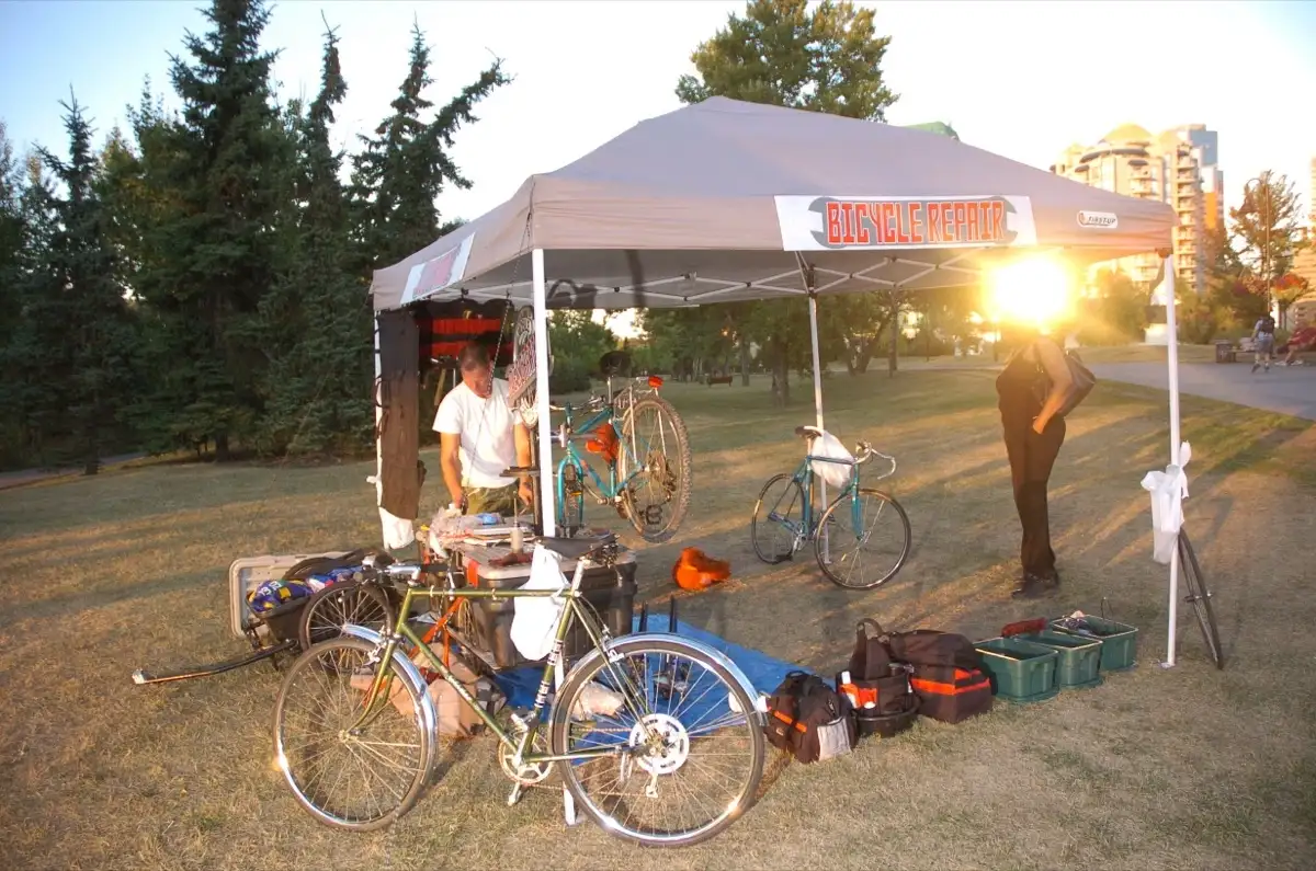 Bicycle repairs under the tent at sunset on the Bow River pathway